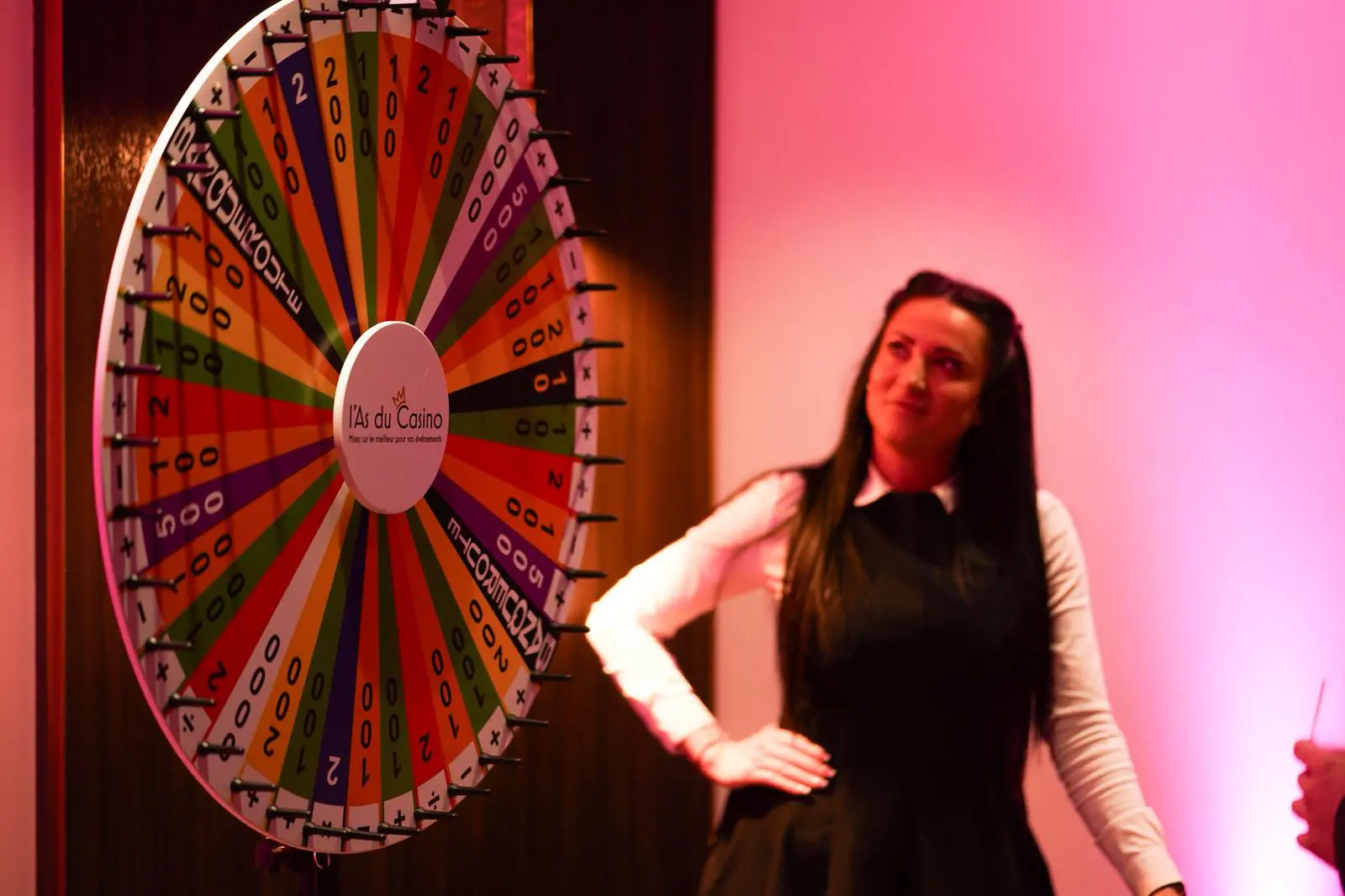 Animatrice de l'As du Casino en pose devant une grande roue de la fortune lors d'une soirée casino d'entreprise à Paris