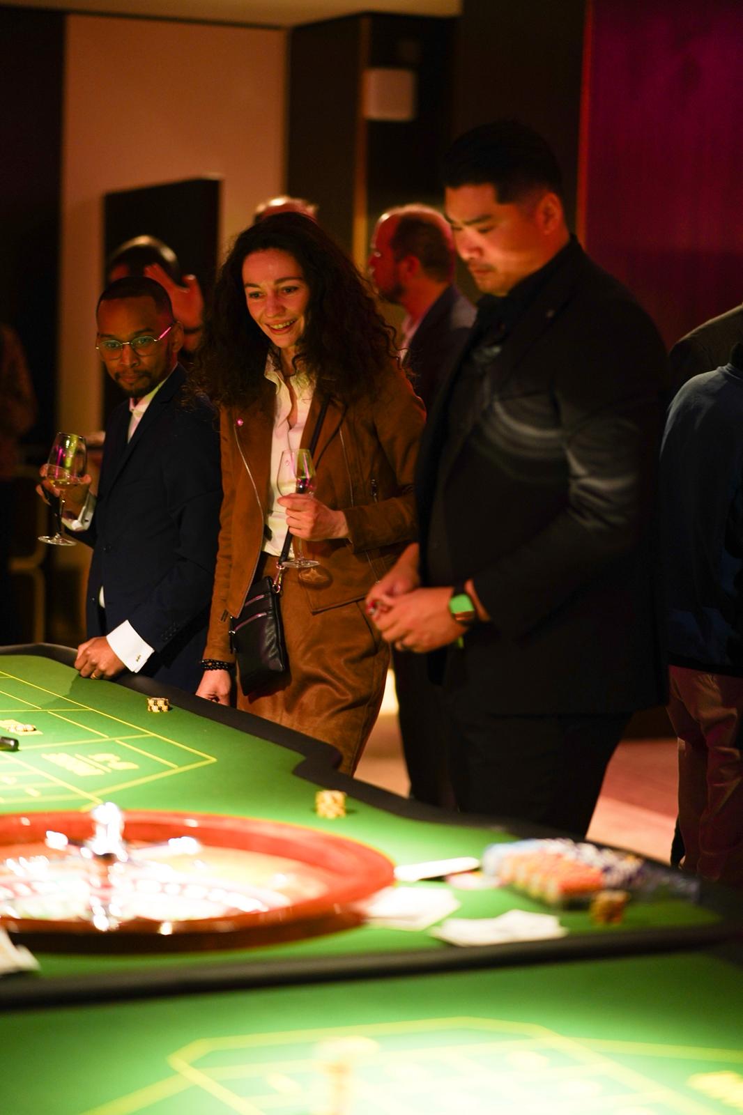 Soirée casino factice — invités jouant autour d'une table de poker