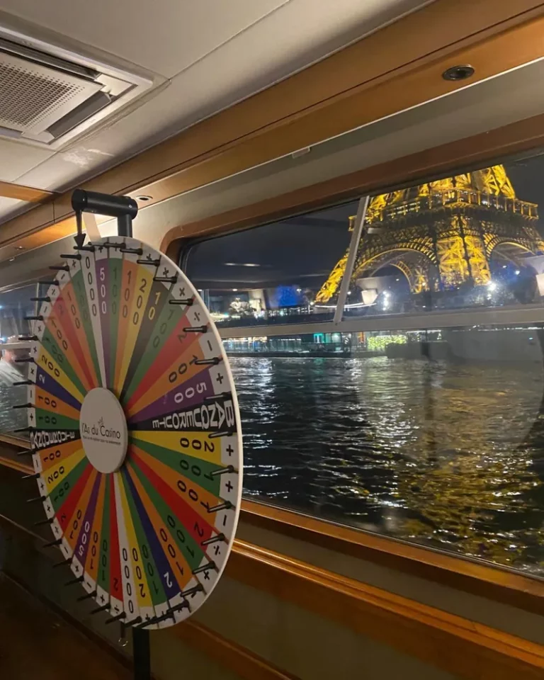 Roue de la fortune L'As du Casino à bord d'un bateau sur la Seine, tour Eiffel illuminée en fond