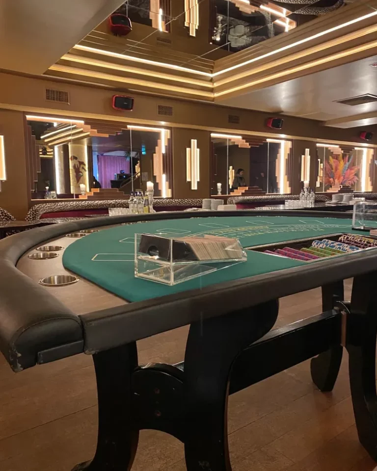 Table de blackjack dressée dans une salle de réception au décor doré avant l'arrivée des invités