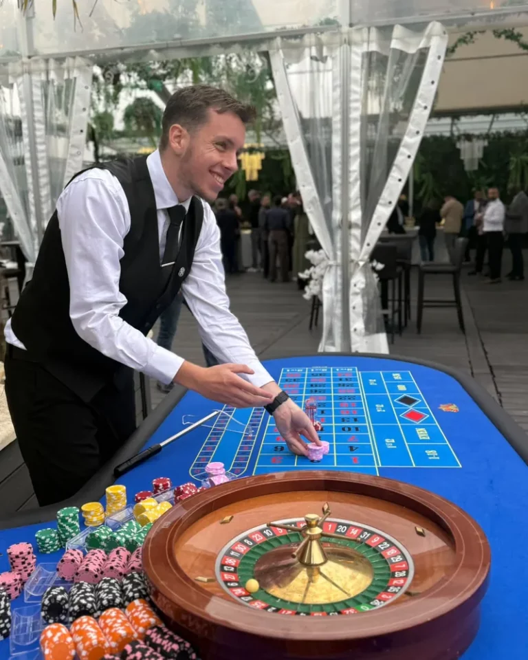 Croupier souriant plaçant les jetons sur une table de roulette bleue sous une tente de réception