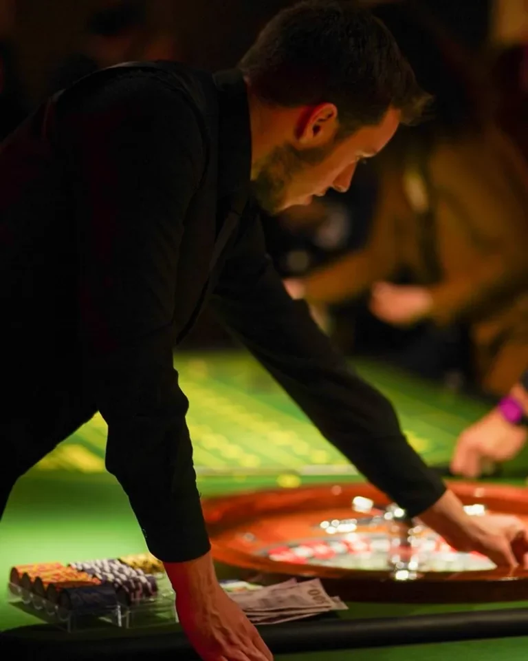 Croupier lançant la bille dans le cylindre d'une roulette lors d'une soirée casino