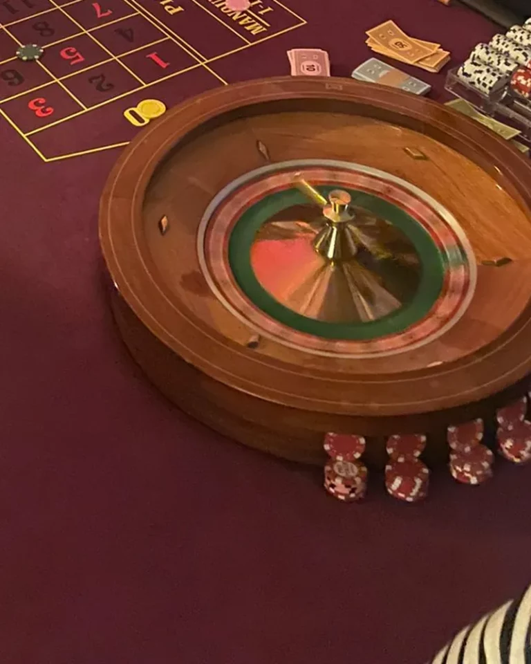 Cylindre de roulette et jetons rouges sur un tapis bordeaux, soirée casino privée