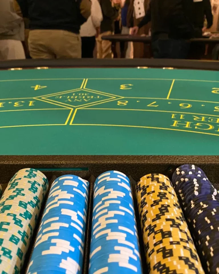 Chariot de jetons de casino colorés devant un tapis de jeu, ambiance de soirée casino