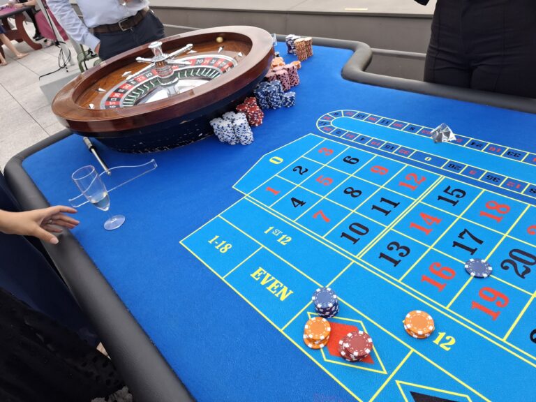 Table de roulette bleue avec jetons, lors d'une soirée casino en extérieur